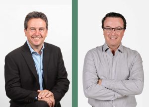 EPSYLON - Deux hommes en tenue professionnelle sourient face à l'appareil photo. L'un porte un costume sombre, l'autre une chemise claire. Fond blanc avec séparation verte.